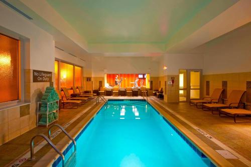a pool in a hotel room with chairs and tables at Residence Inn Pittsburgh North Shore in Pittsburgh