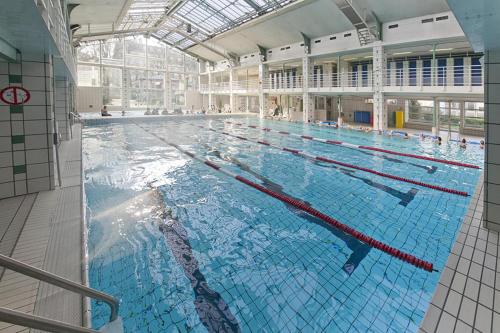 une grande piscine dans un grand bâtiment dans l'établissement Grande Chambre ARENA, à Paris