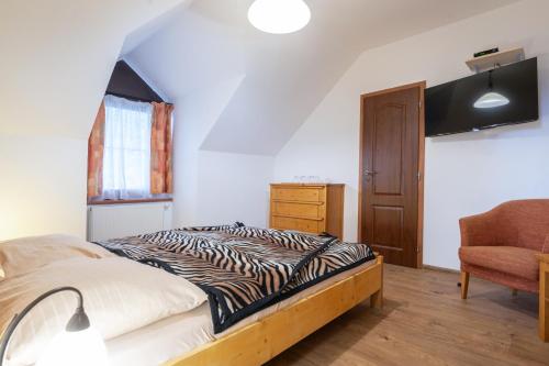 a bedroom with a bed and a chair at Rezort u Bobiho in Nový Tekov