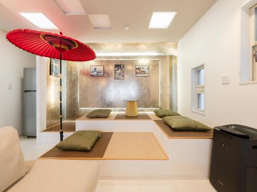 a room with three couches and a red umbrella at Shinjuku 2min 140 Square meters VR Switch Photo Booth pc in Tokyo