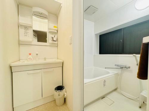 un bagno bianco con lavandino e vasca di Oji House-KI0022 a Tokyo