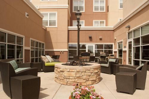 a patio with chairs and a fire pit in a building at Residence Inn by Marriott Stillwater in Stillwater