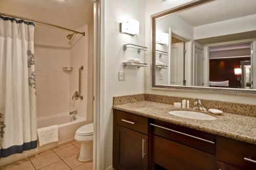 a bathroom with a sink and a toilet and a mirror at Residence Inn by Marriott Stillwater in Stillwater