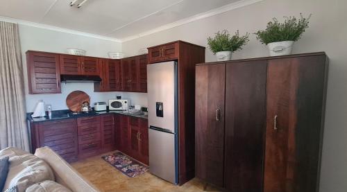 a kitchen with wooden cabinets and a white refrigerator at Upstairs R-1 Self-Catering Unit in White River
