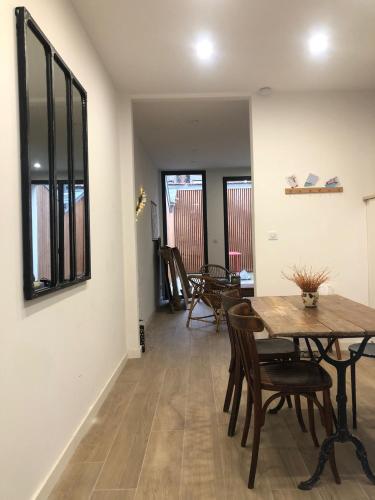une salle à manger avec une table et des chaises en bois dans l'établissement La Louisette, à Fécamp