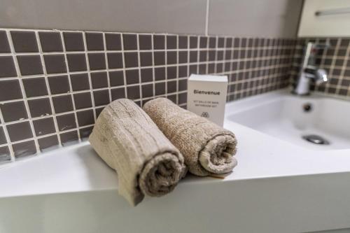 - deux serviettes assises sur un lavabo dans l'établissement L 'Émeraude Toulousaine, à Toulouse