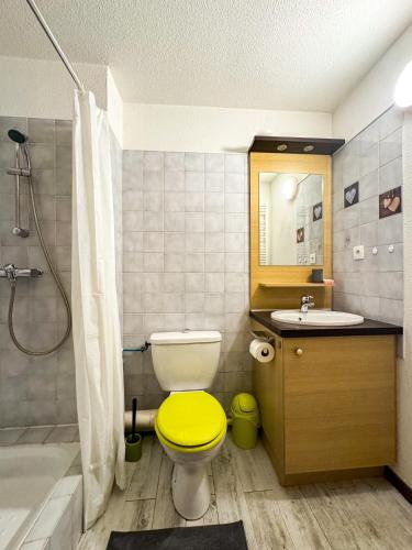 La salle de bains est pourvue de toilettes jaunes et d'un lavabo. dans l'établissement 5- Brides-les-Bains Studio de charme avec vue montagne, à Brides-les-Bains