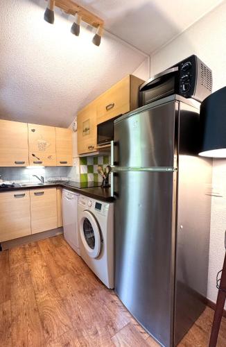 Il comprend une cuisine équipée d'un réfrigérateur et d'un lave-linge/sèche-linge. dans l'établissement 5- Brides-les-Bains Studio de charme avec vue montagne, à Brides-les-Bains