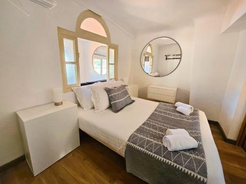 une chambre avec un lit avec deux oreillers et un miroir dans l'établissement Bay Menton Sea View Old Town, à Menton