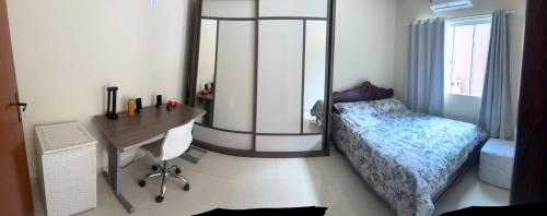 a bedroom with a bed and a desk and a desk at Casa da Pri in Rio das Ostras