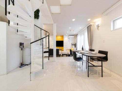 a dining room and living room with a staircase and a table at Shinjuku 2min 140 Square meters VR Switch Photo Booth pc in Tokyo
