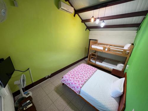 a small room with a bed and a green wall at Color Rainbow Home in Taimali