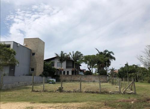 a house with a fence in front of it at Espaço para Motor Home ou Trailer in Garopaba