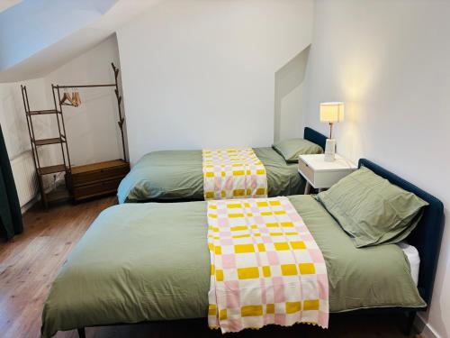 two beds in a small room with at Cosy & Modern in London