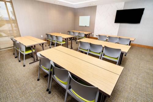 a classroom with tables and chairs and a flat screen tv at SpringHill Suites by Marriott Ontario Airport/Rancho Cucamonga in Ontario