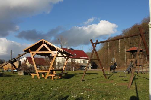 a playground with a wooden structure in a field at Kutschergasthof Am Sonnenstein in Sonnenstein