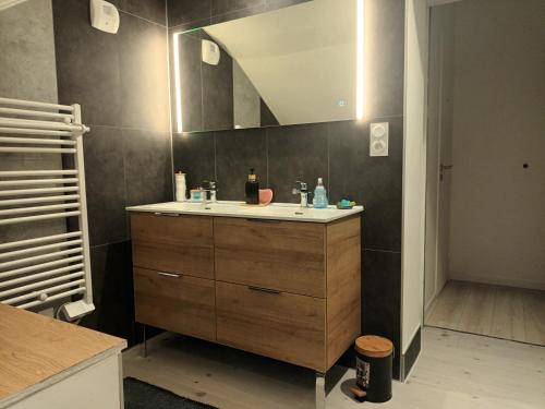 une salle de bain avec un lavabo et un miroir dans l'établissement Magnifique Duplex Gîte Gambetta familial, à Ploumagoar