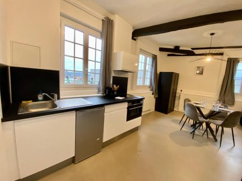 une cuisine avec un évier et une table avec des chaises dans l'établissement Henry II - Petit appartement lumineux - 013, à Rouen
