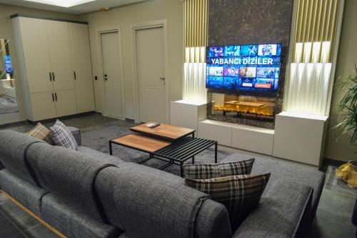 a living room with a couch and a tv at LİMONOTTO SUİT OTEL in Mersin