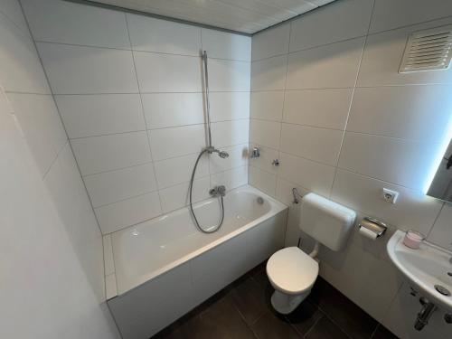 a bathroom with a tub and a toilet and a sink at Apartment am Messegelände in Nürnberg