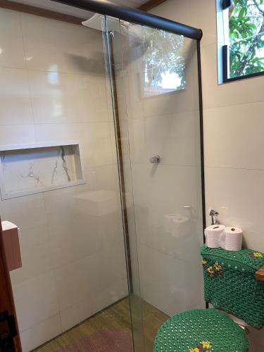 a shower with a glass door in a bathroom at Chalé Cabana Lumiar in Nova Friburgo