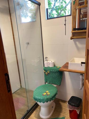 a bathroom with a toilet and a glass shower at Chalé Cabana Lumiar in Nova Friburgo