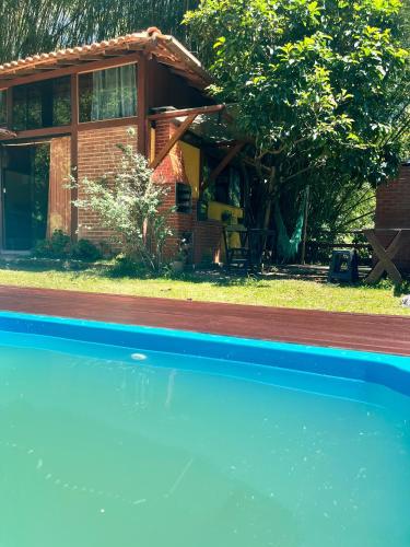 a house with a swimming pool in front of it at Chalé Cabana Lumiar in Nova Friburgo