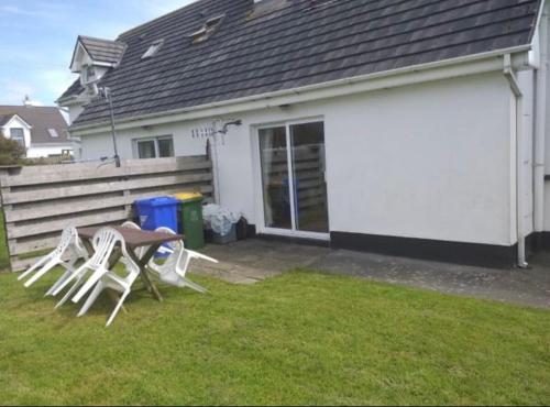 a table and chairs in front of a house at Fionas Seaside Cottage in Ballybunion