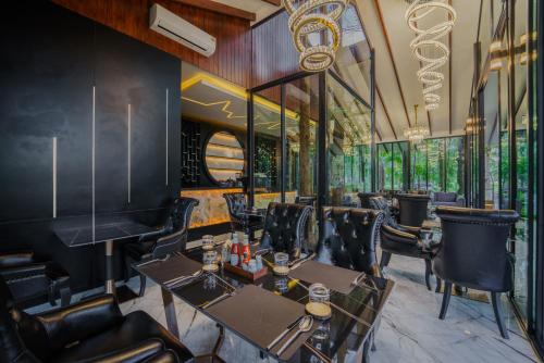 a restaurant with tables and chairs and windows at High Tree Resort, Krabi in Ao Nam Mao
