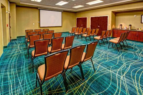a conference room with chairs and a whiteboard at SpringHill Suites Norfolk Old Dominion University in Norfolk