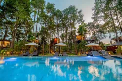 a pool at a resort with chairs and umbrellas at High Tree Resort, Krabi in Ao Nam Mao