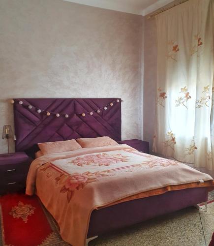 フェズにあるAppartement au centre-ville de Fèsの紫色のベッド1台(紫色のヘッドボード付)