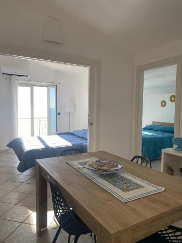 a living room with a table and a bedroom at VistaMare in Realmonte