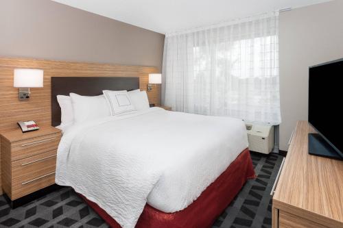 a hotel room with a bed and a flat screen tv at TownePlace Suites by Marriott Titusville Kennedy Space Center in Titusville