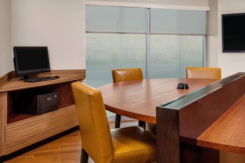 a conference room with a wooden table with chairs and a computer at TownePlace Suites by Marriott Titusville Kennedy Space Center in Titusville