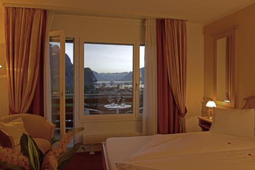 a hotel room with a bed and a large window at Hotel Brienz in Brienz