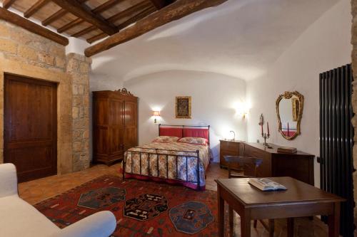 a bedroom with a bed and a table at La Casa Degli Archi in Pitigliano