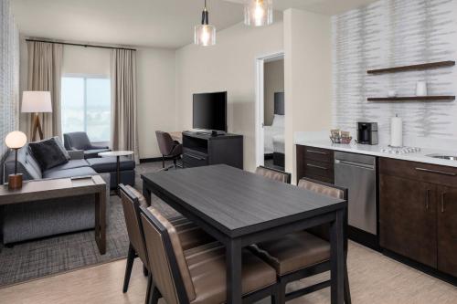 a kitchen and living room with a table and a couch at Residence Inn by Marriott East Peoria in Peoria