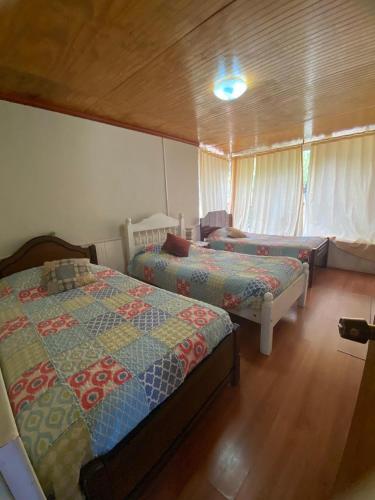 a bedroom with two beds in a room at Casa de campo con piscina y quincho in Estación Maquegua