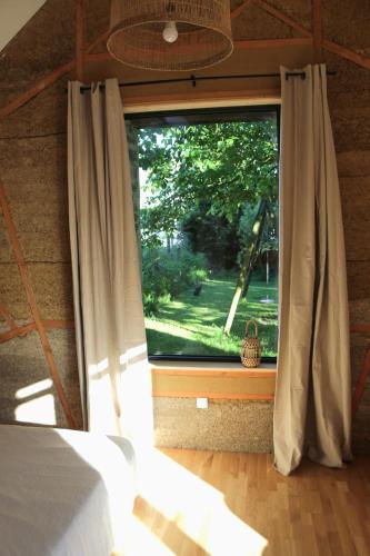 a bedroom with a window with a view of a yard at Hébergement indépendant centre bourg in Nozay
