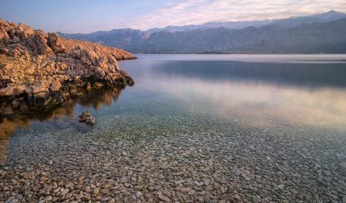 une grande étendue d'eau avec des montagnes en arrière-plan dans l'établissement Guest house Brodarica, à Brodarica