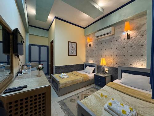 a hotel room with two beds and a sink at Sababa Hotel in Dahab