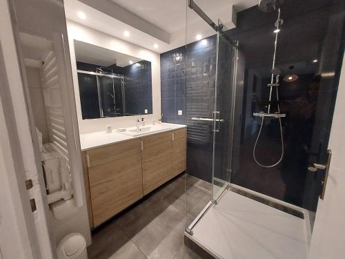 une salle de bain avec une douche et un lavabo et une cabine de douche en verre dans l'établissement Résidence ERMITAGE. Appartement pour 4 personnes au centre-ville d'Hossegor. Wifi gratuit, à Soorts-Hossegor