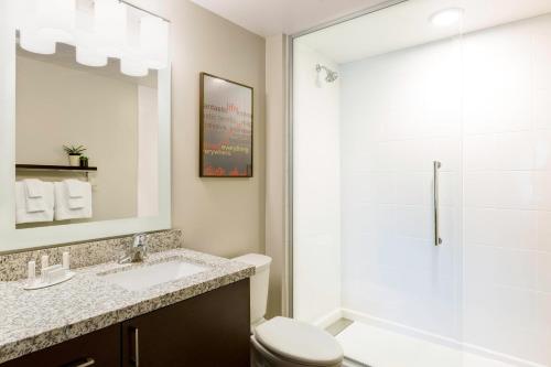 a bathroom with a shower and a toilet and a sink at TownePlace Suites by Marriott Pittsburgh Harmarville in Harmarville