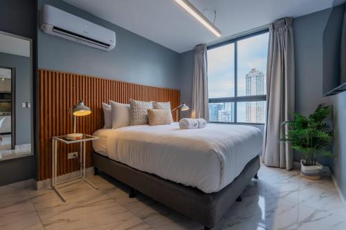 Un dormitorio con una cama grande y una ventana grande en The Gray by Wynwood House, en Panamá
