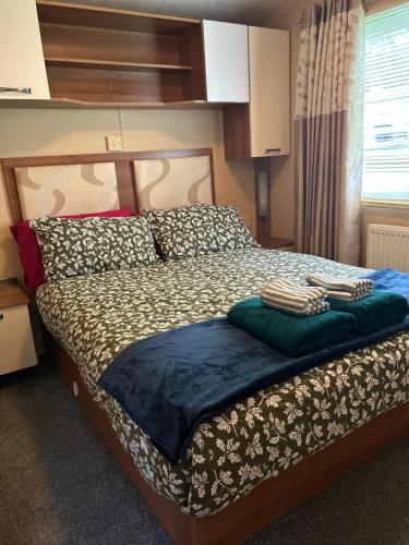 a bedroom with a bed with two towels on it at 23 Chestnut Grove in Kirkcolm