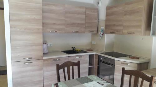 a kitchen with wooden cabinets and a table with chairs at Mar Mar Appartaments in Briançon