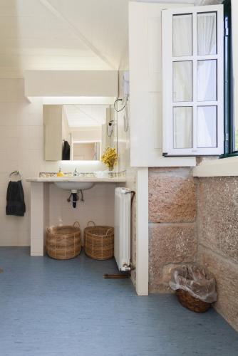 a kitchen with a sink and a counter with baskets at Quinta da Comenda in São Pedro do Sul