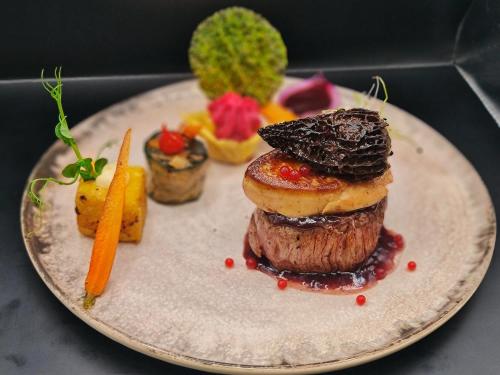 a plate of food with a pastry and a carrot at Le PasSionNant in Morzine
