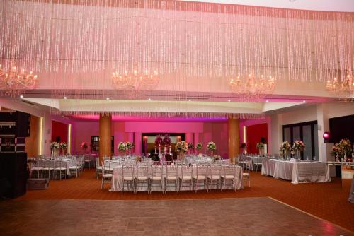 a banquet hall with white tables and chandeliers at Wyndham Executivo Culiacan in Culiacán